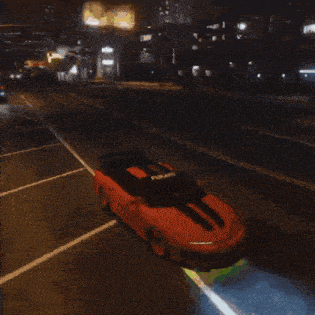 a car is driving down the street at night