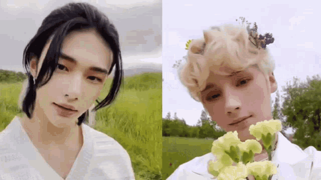 a man with long hair is standing in a field next to a man with blonde hair holding flowers .