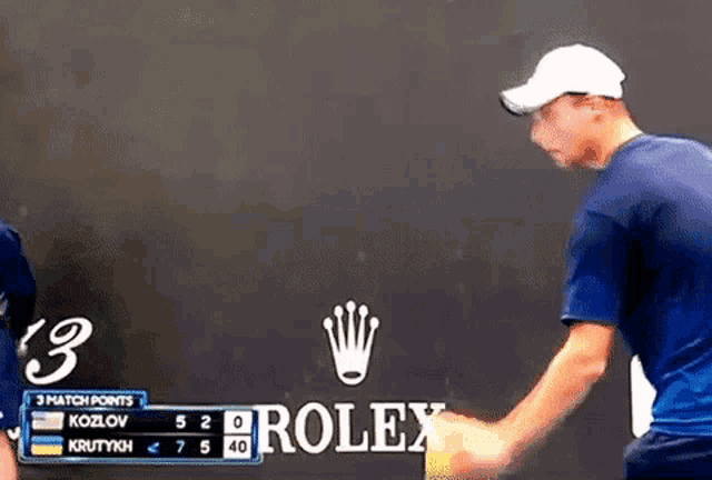 a rolex logo can be seen behind a man in a blue shirt