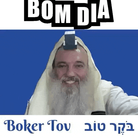 a man with a beard and a towel on his head is smiling and holding a card on his head .