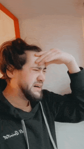 a man with a beard wearing a black sweatshirt that says ' twisted 13 ' on it