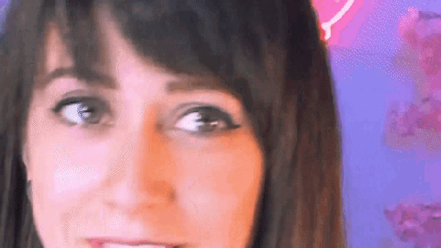 a close up of a woman 's face with a pink heart on her head