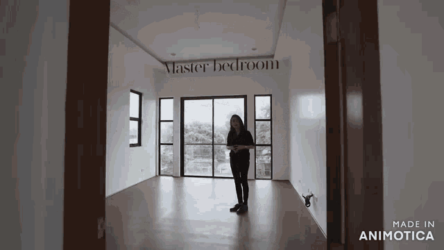 a woman is standing in an empty room with the words master bedroom on the wall