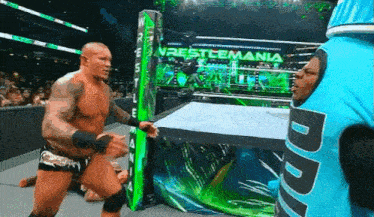 a wrestling match is taking place in front of a sign that says ' restlemania '