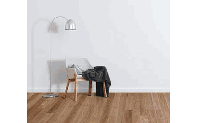 a chair with a blanket and a lamp on the floor