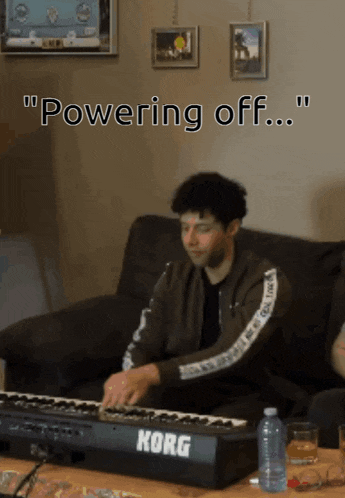 a man is playing a korg keyboard on a couch