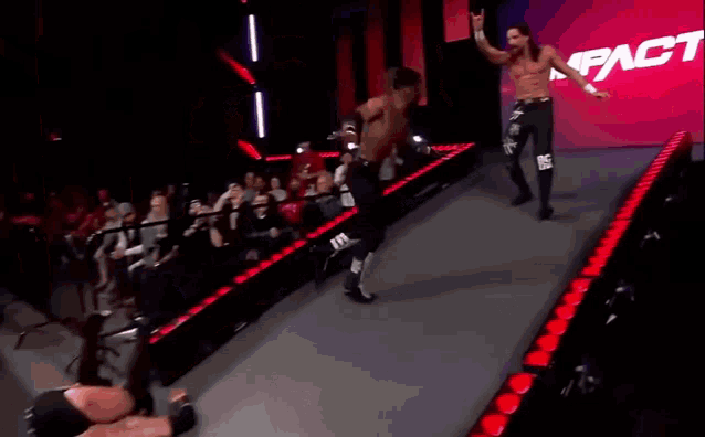 two wrestlers are standing in front of a red sign that says " fact "