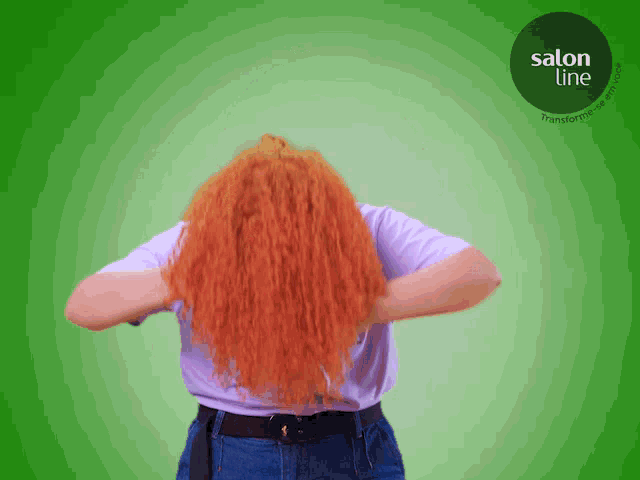 a woman with red hair is standing in front of a green background that says salon line on it