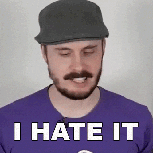 a man with a beard wearing a hat and a purple shirt is saying i hate it .