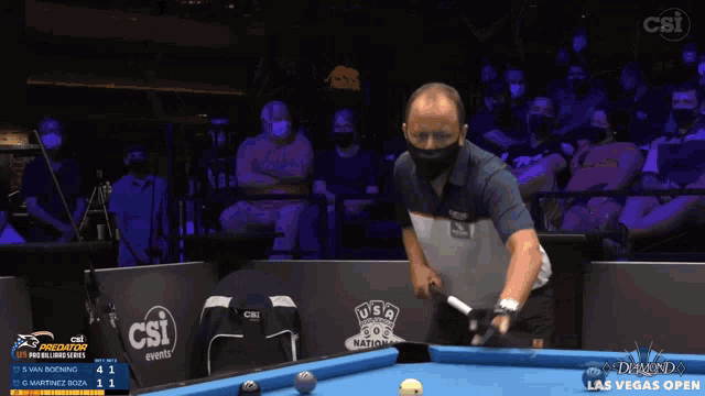 a man is playing pool in front of a crowd at the las vegas open