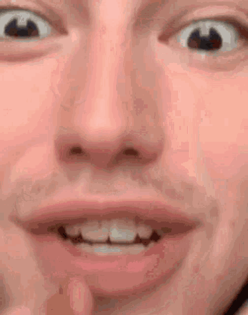 a close up of a man 's face with a beard and teeth smiling .