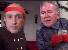a bald man wearing a red headband is standing next to another bald man