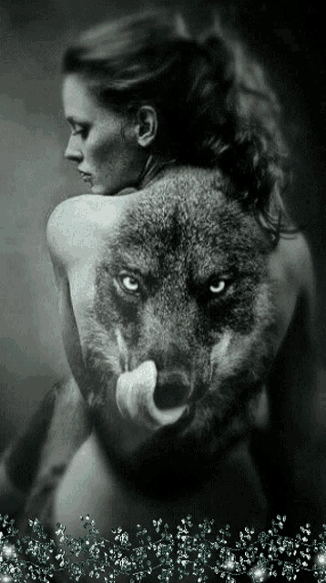 a woman is holding a wolf on her back