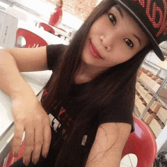 a woman wearing a hat with the letter s on it is taking a selfie