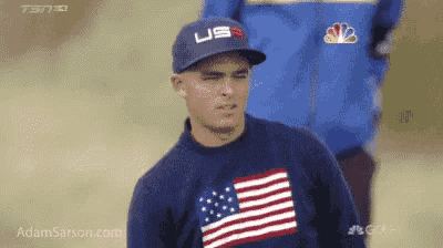 a man wearing a hat and a sweater with an american flag on it