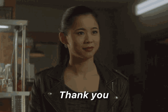 a woman wearing a leather jacket says thank you