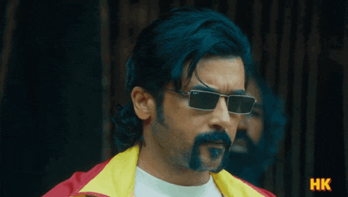 a man with a beard wearing sunglasses and a yellow jacket