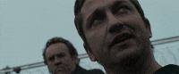 two men are standing next to each other and one of them is looking up at the camera .