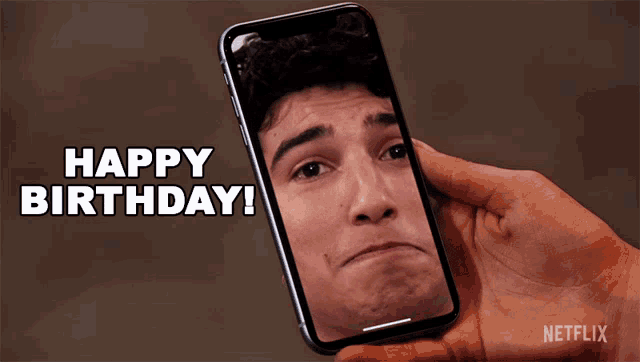 a person holding a cell phone with a picture of a man on the screen and the words happy birthday