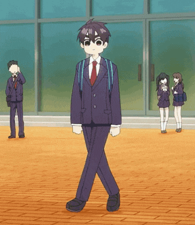 a boy in a suit and tie is walking in a school hallway