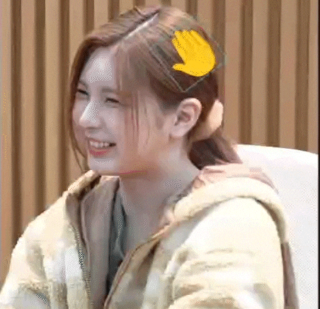 a woman with a yellow hand in her hair is smiling .