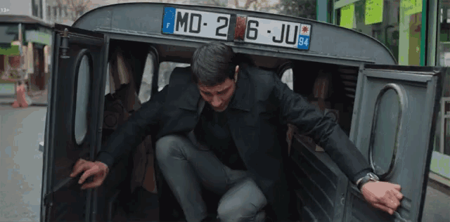 a man is getting out of a car with a license plate that says md-2 6 ju 84