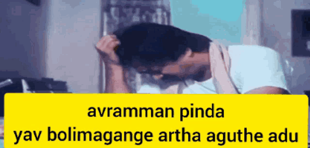 a man with his head in his hands is behind a yellow banner that says avramman pinda