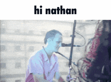 a man singing into a microphone with the words hi nathan written above him