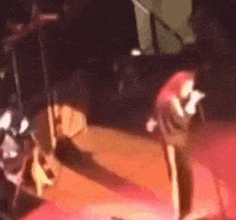 a woman with red hair is singing into a microphone on a stage