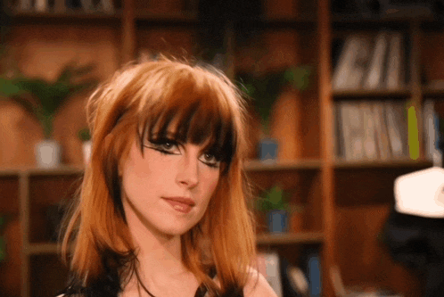 a woman with red hair and black eye makeup