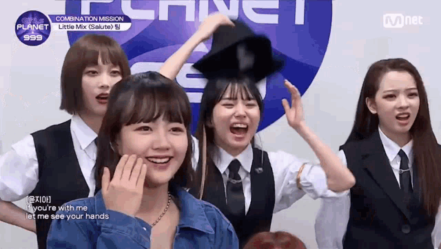 a group of girls are standing in front of a sign that says mnet