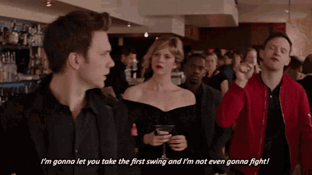 a man in a red jacket says " i 'm gonna let you take the first swing "