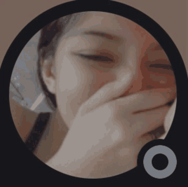 a woman covering her face with her hand in a circle
