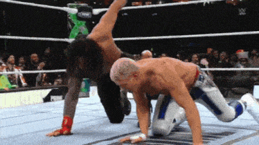 two men are wrestling in a ring and one of them is wearing a blue and white outfit