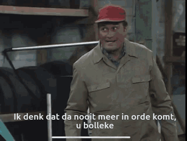 a man in a red hat stands next to a blue car with the words ik denk dat da nooit meer in orde komt