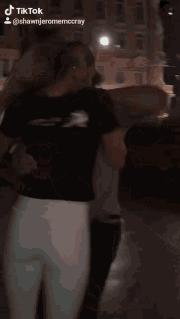 a woman in a black shirt and white pants has a tiktok account