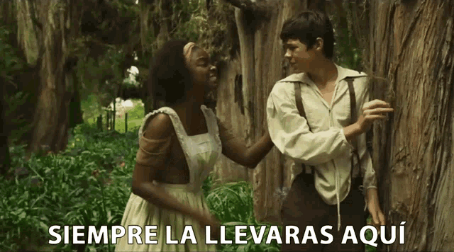 a man and a woman standing next to a tree with siempre la llevaras aqui written in white letters