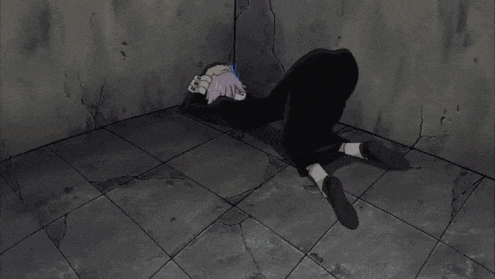 a person with purple hair is laying on the floor in a corner