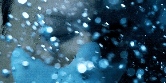 a close up of a person 's face with water bubbles coming out of it