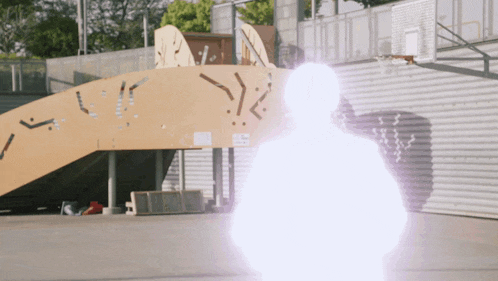 a person standing in front of a basketball hoop with a light coming out of their hand