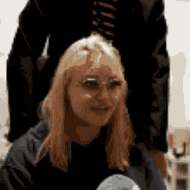 a woman wearing glasses is sitting on a man 's lap