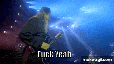 a man with long hair is playing a guitar on a stage with the words fuck yeah in the background .