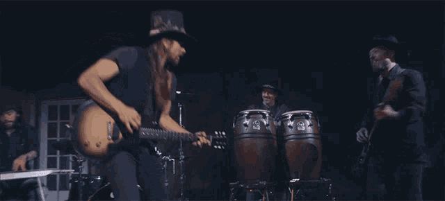 a man in a top hat plays a guitar
