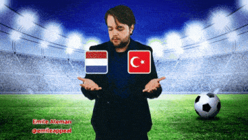a man in a suit stands in front of a soccer field with a soccer ball and two flags on his shoulders