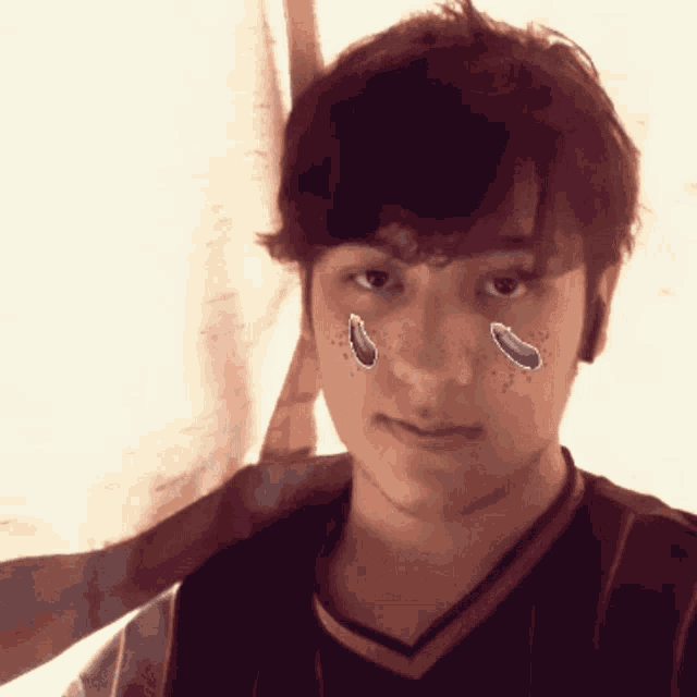 a young man with tears on his face is wearing a jersey