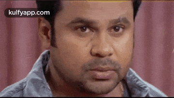 a close up of a man 's face with a beard looking at the camera .