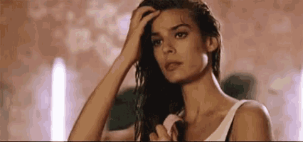 a woman is brushing her hair with a pink brush .