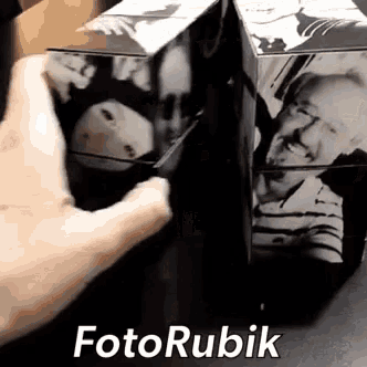a person is holding a photo cube with a picture of a man on it .