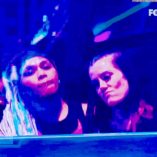 two women are standing in front of a screen that says fox on it