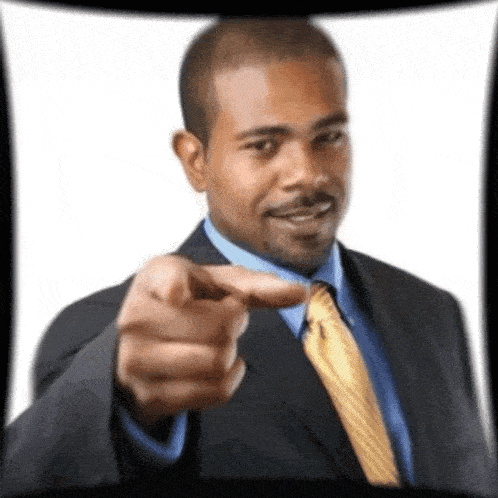 a man in a suit and tie is pointing his finger at the camera